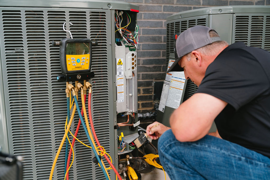 An Air Repair Pros technician diagnosing a residential condenser with manifold gauges and electrical meters in North Texas